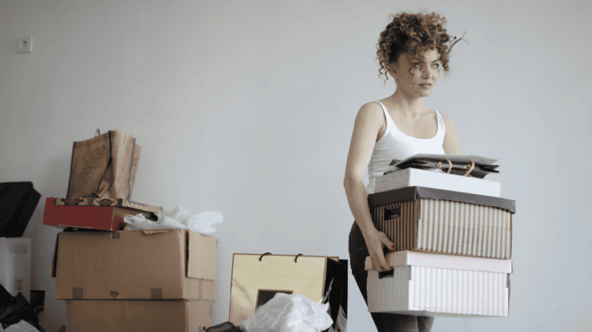 Young woman moving boxes out of a home
