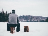 Man sitting on stump in the snow