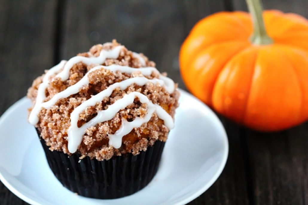 Pumpkin Muffin on a white plate with a small pumpkin next to it. This is our winning pumpkin muffin recipe! 