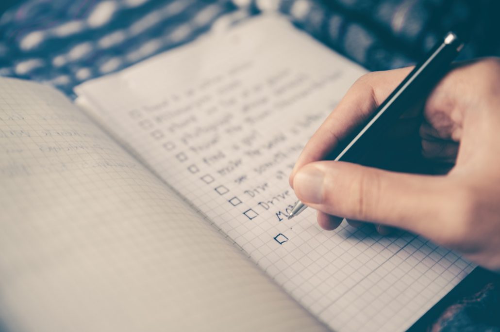 Person writing out a to-do list to help manage their time. 