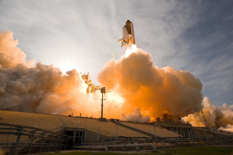 A rocket ship launches into the sky at sunset. 