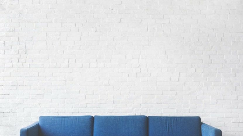 Blue sofa in front of white wall