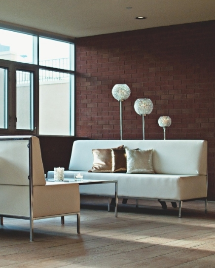 White couches in front of red brick wall indoors