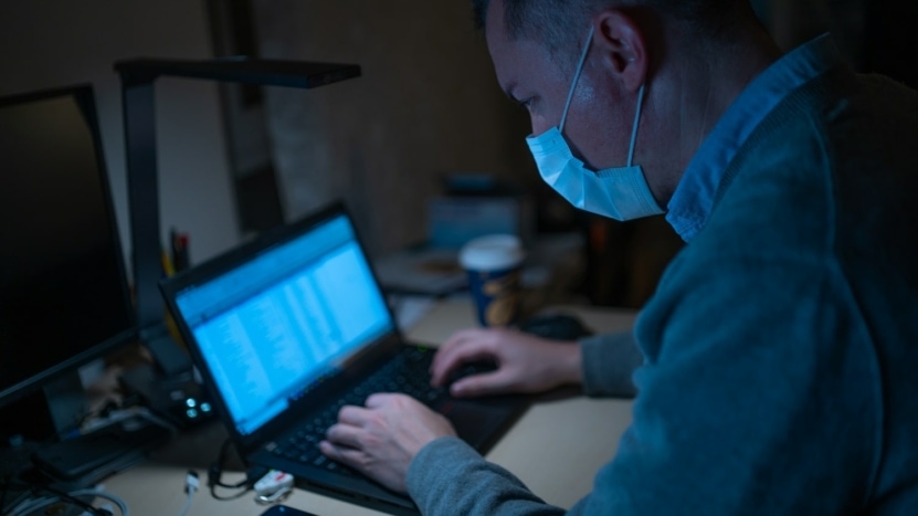 Man looks up interest rates from home on a laptop during the Bay Area shutdown due to the Shelter in Place order to prevent the spread of COVID-19.