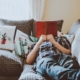 texas man reclining on a cocuh with cactus pillows reading a red book about mortgage rates
