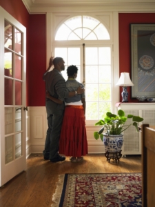 Young couple standing by window in living room