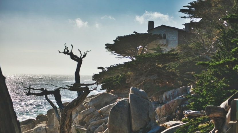 home on a sea side cliff with trees and brush in Carmel California where many are moving to this suburbi to avoid higher rent and longer commutes and safer overall living