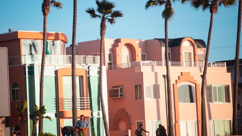 Art Deco style building by the beach in blue and salmon pastel colors. Homeowners should consider refinancing now!