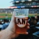 Baseball fan holds a beer in the baseball stadium during a game.