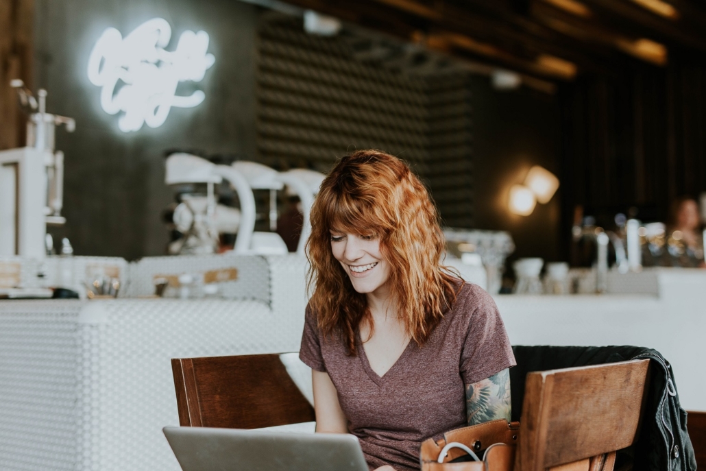 A woman applies for a mortgage online with her laptop in a coffee shop, there are many factors that can affect the interest rate borrowers qualify for.