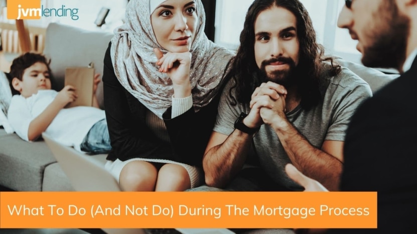 A couple in the homebuying process sit on a couch and listen to their mortgage lender explain the dos and don'ts during the mortgage process