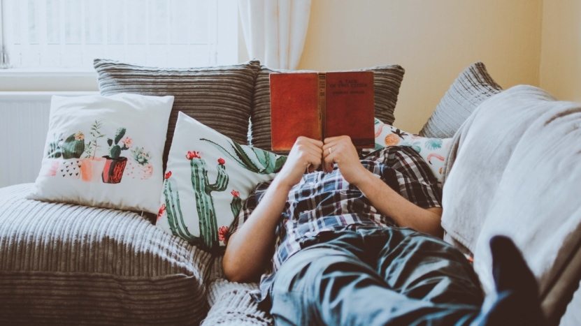 Person on couch reading a book