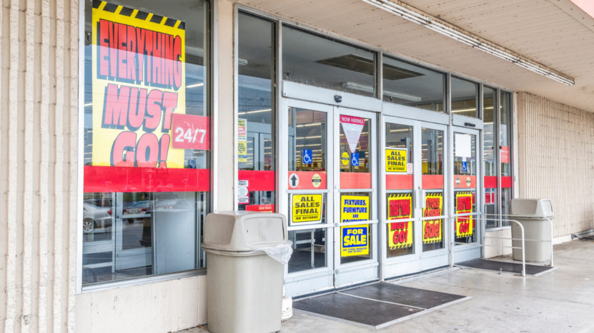 Business that fail to innovate often get killed in the future. This storefront of a business is covered in signs advertising closing sales because they are shutting down.