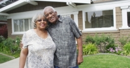 Retired African couple embracing each other on yard