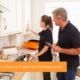 A young homebuyer and home inspector look at the kitchen and asses additional repair costs that will need to be added to the total closing costs.