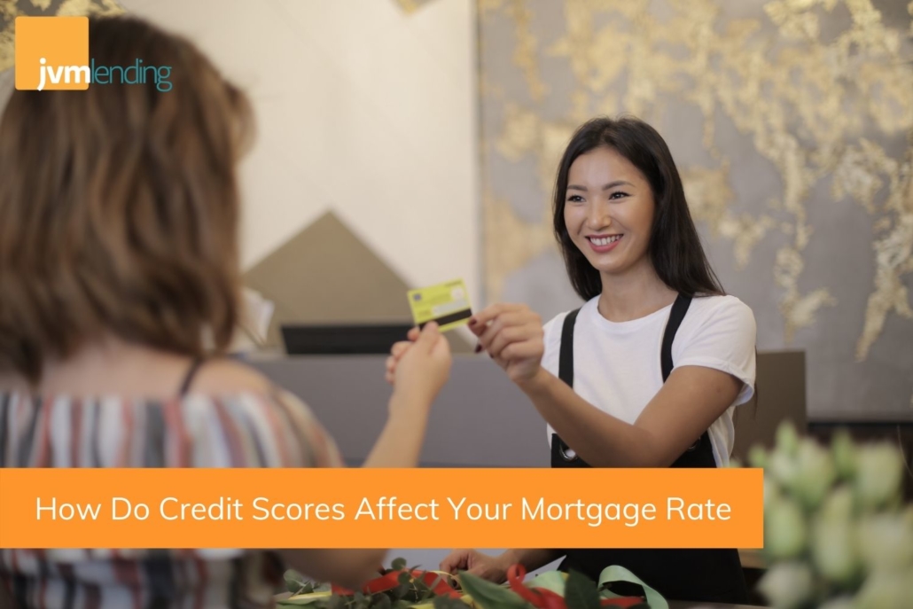 A young woman uses her credit card to pay off her bills. Credit scores can affect your mortgage interest rate.