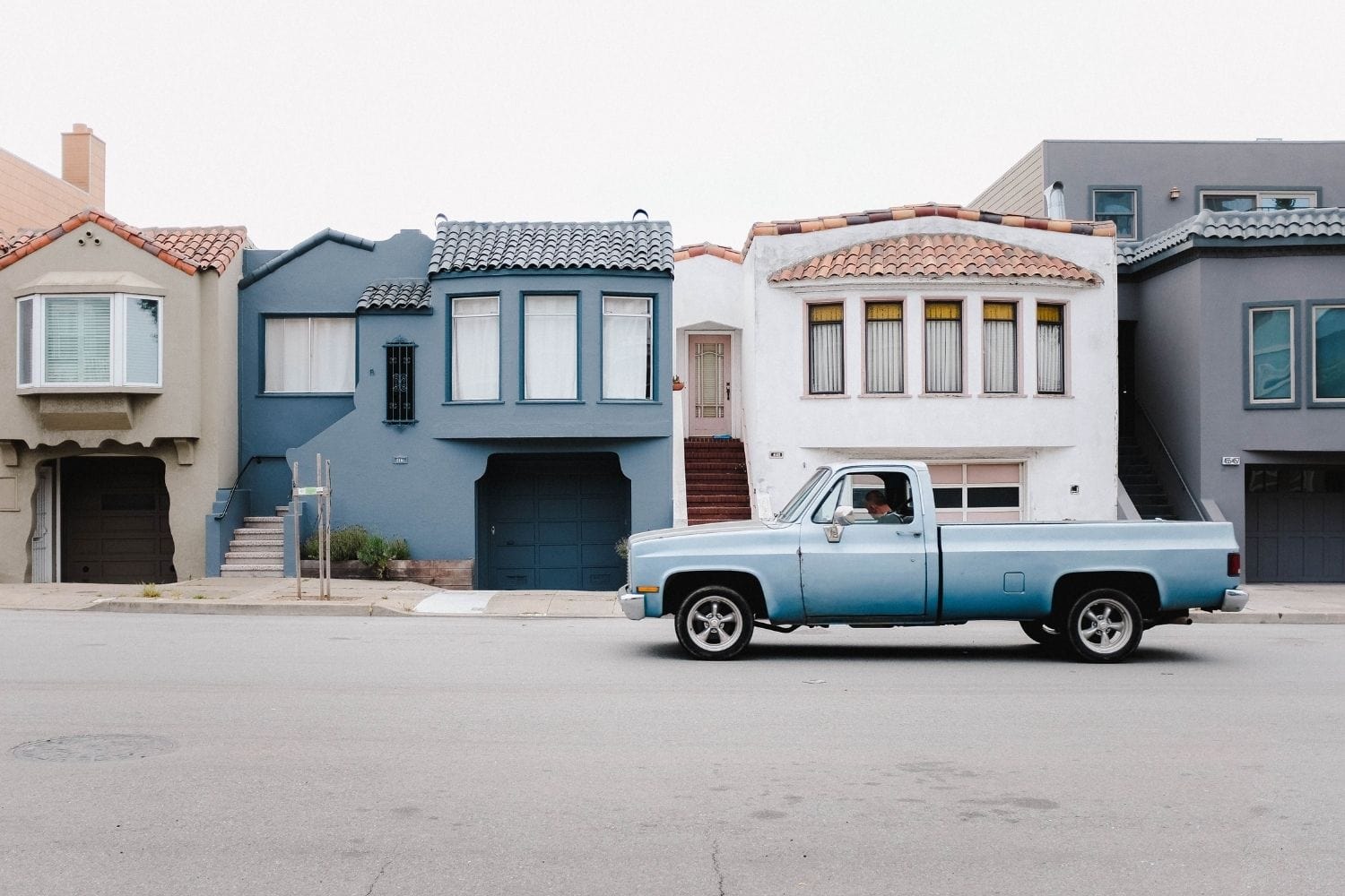Old blue truck parked in front of san francisco houses