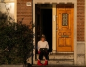 A woman sits on the stoop of her home while working on her loan application on her laptop computer. Many people could benefit from taking lender credits in today's rate environment.
