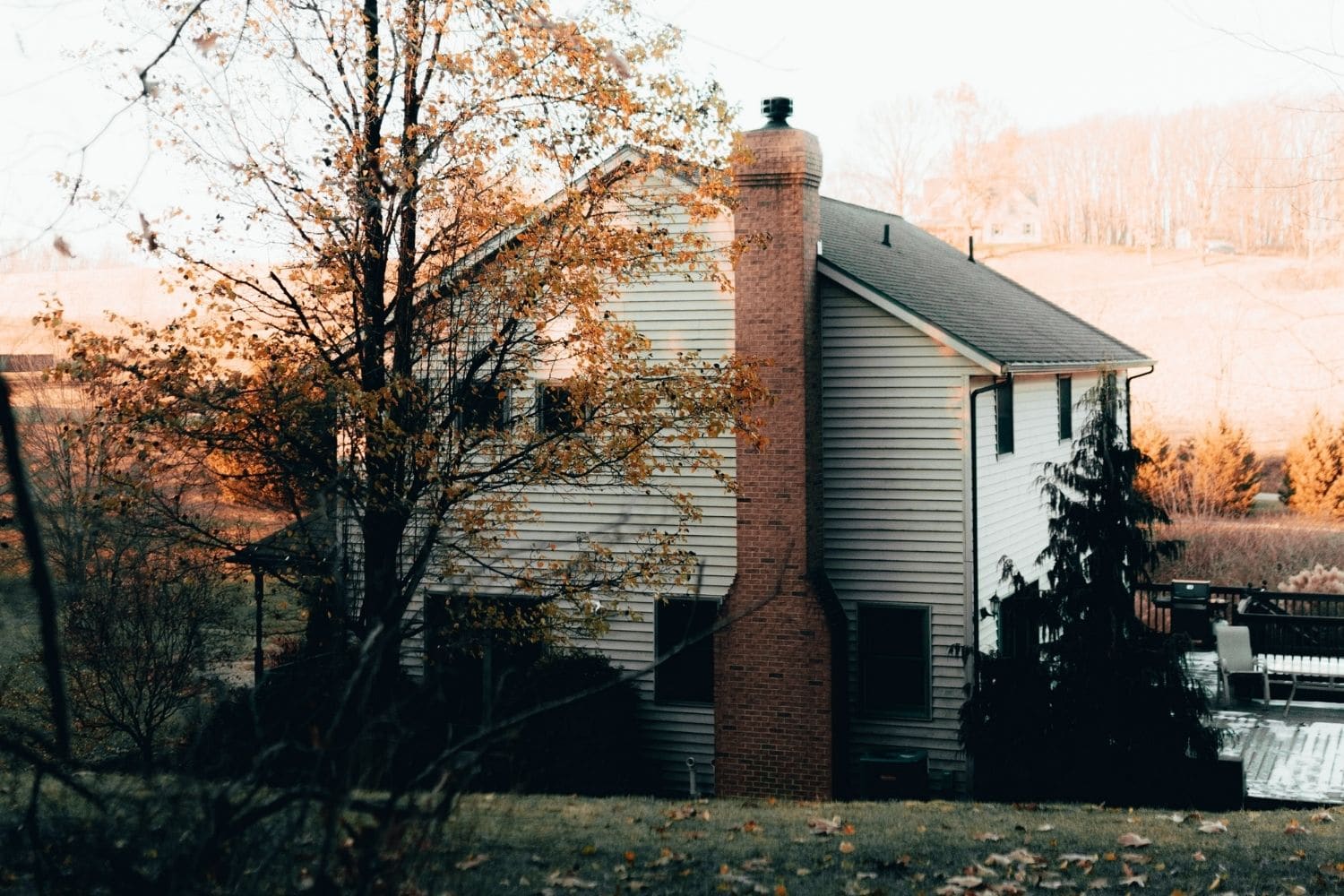 A house with fall colors is owned by homeowners who are considering if they should refinance their home.
