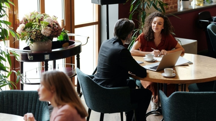 a first time homebuyer meets her real estate agent at a restaurant for lunch to discus which type of mortgage lender is better for her, a small lender or a big lender.