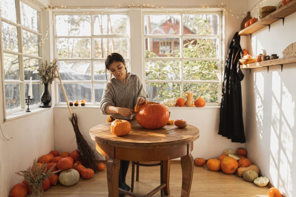 A homeowner carves a pumpkin in her kitchen on the table. She purchased her home and had to deal with setting up her payments with the new loan servicer.