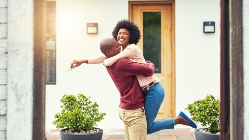 Couple hugs in celebration of buying a home