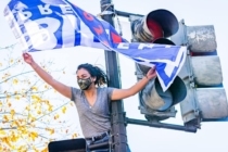 Woman in a mask holding Joe Biden flag