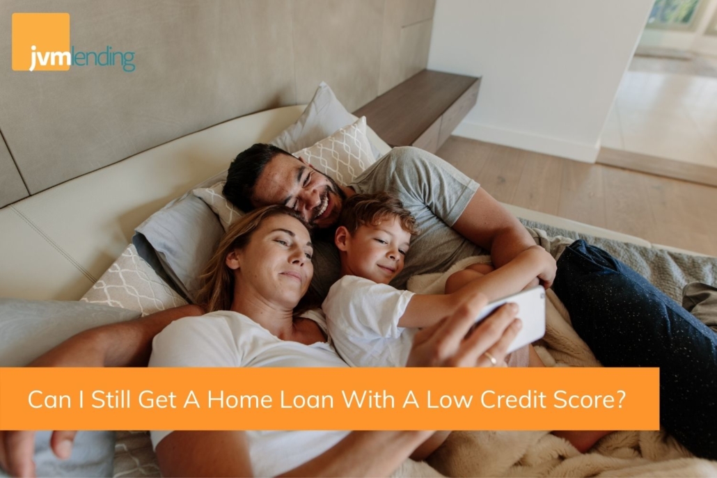Family of three lay in bed together looking at a phone that displays information on applying for a home loan with low credit