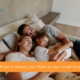 Husband, wife, and son laying in bed smiling looking at a phone