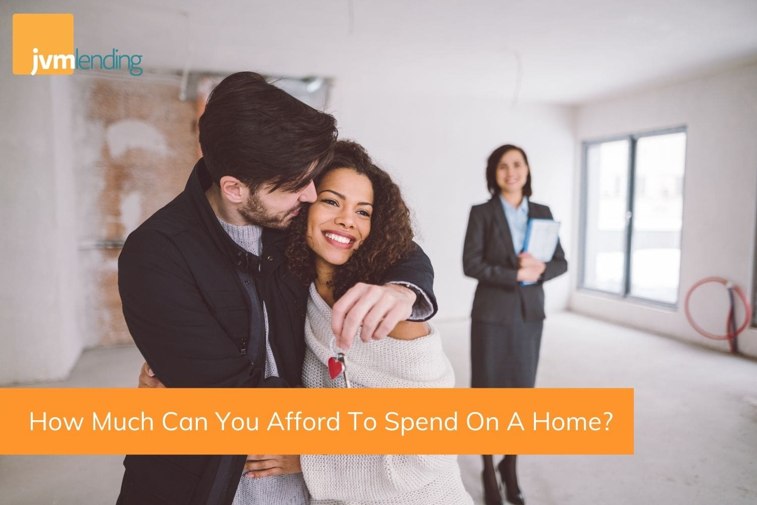 A young couples smiles while holding the keys to a new home with their real estate agent. After careful planning, they found out how much they could afford to spend on a home and purchased their first home.