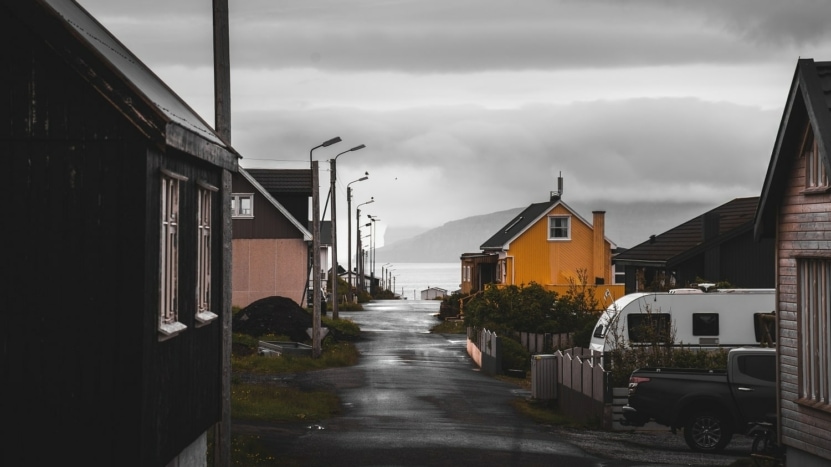 A neighborhood street with homes by the ocean on a rainy day were purchased with by homebuyers with low mortgage rates.
