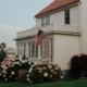 A white house with a terracotta roof sports an American flag hung by a first-time veteran homebuyer.