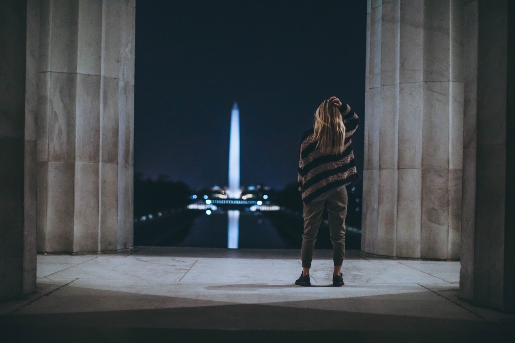 A woman looks at the Washington Monument at night after Democrats won the Georgia Senate and rates went up in response.