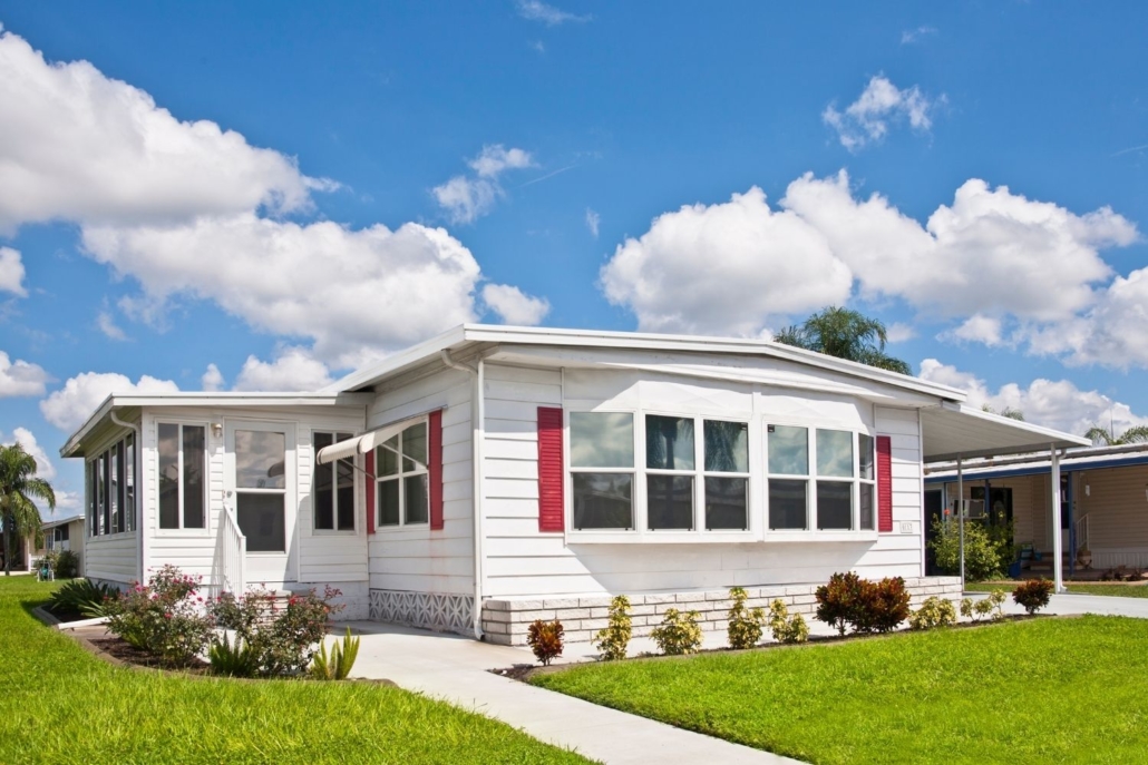 exterior of a white manufactured home on a bright sunny day with a blue sky 