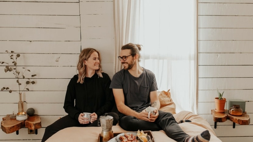 A couple has breakfast in bed of the new home that they purchased despite the recent shortage of housing inventory due to hedge funds purchasing more homes.