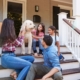 Family of four moving into house sitting on stairs with dog