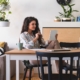 woman sits at table holding a tablet reads about business strategies