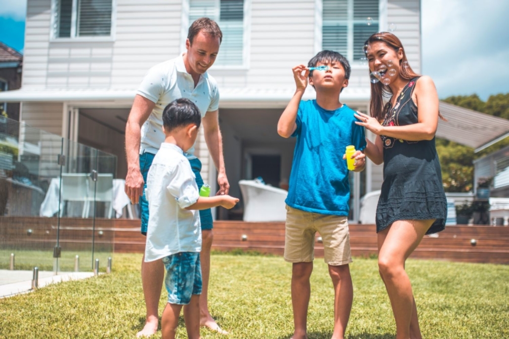 A family of four are are blowing bubbles in front of a home that they bought despite fears of a housing bubble. 
