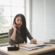 Woman talks on the phone while at desk with laptop open