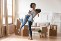 Couple celebrating in new home with moving boxes around them
