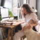 Woman petting dog while at desk in home office