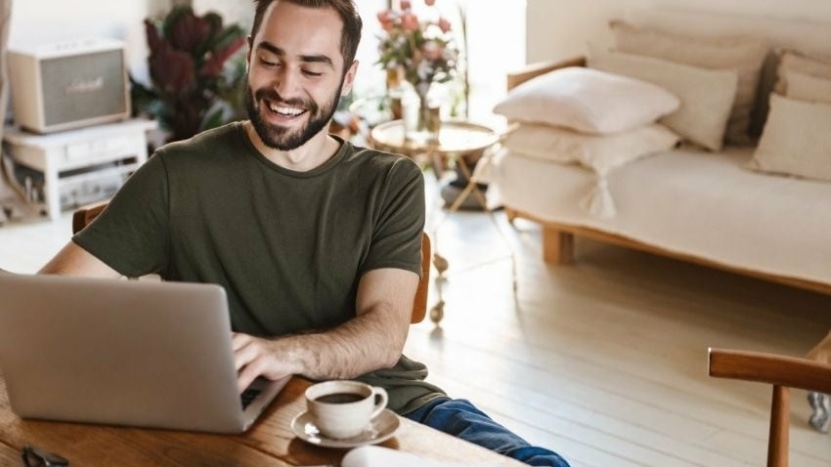 man sitting at home looks up interest-only loans on his laptop