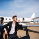 Wealthy business man stands in front of private plane