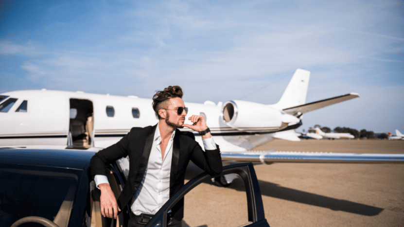 Wealthy business man stands in front of private plane