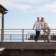 Older couple stand on beach deck