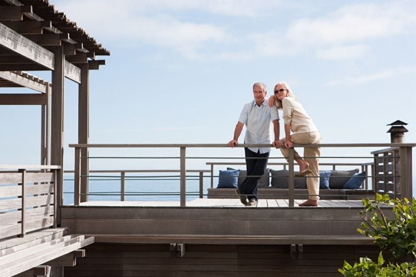 Older couple stand on beach deck