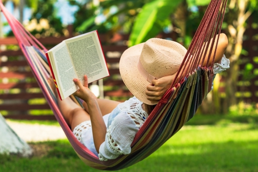woman in hammock reads about high savings rates while on vacation
