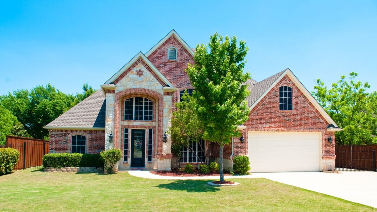 Two story brick residential home with the garage in the front.