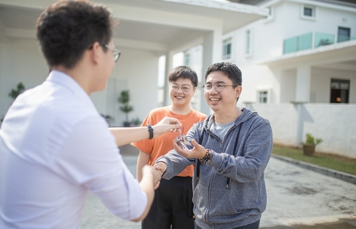 Asian Chinese family moving into new house and received the house key from real estate agent after getting a foreign national loan