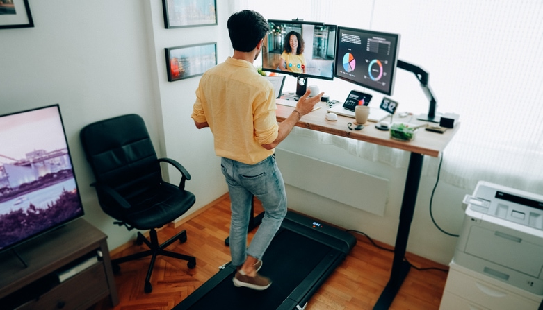 Self-employed man at standing desk home office talking on business video call